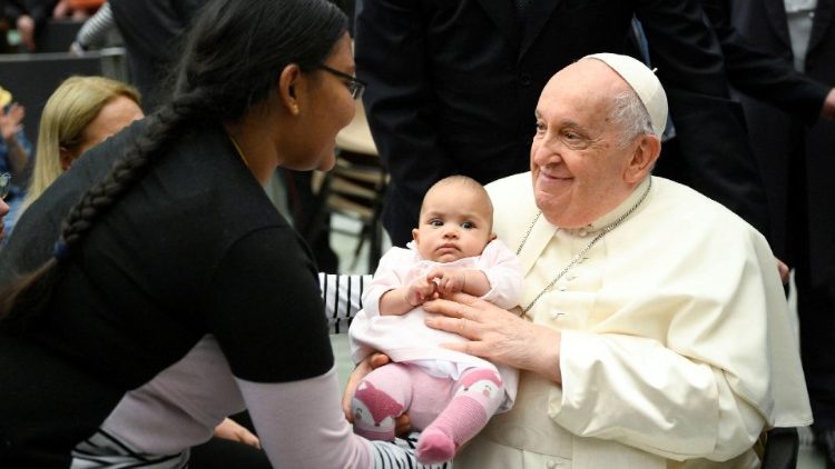 A ternura de Francisco com uma criança nos braços